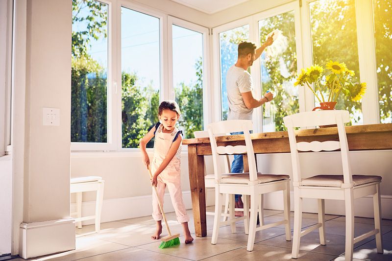 A young girl sweeps a floor. How Environmental Issues Can Affect Your AC.