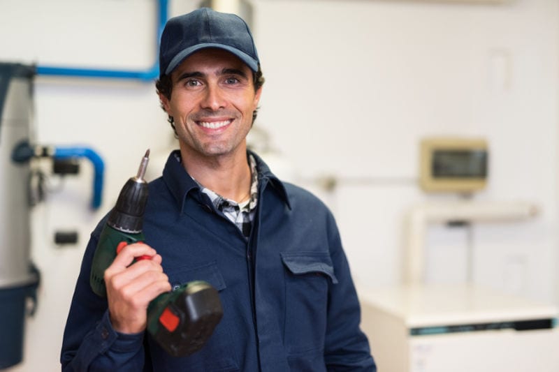 Smiling worker holding a Drill
