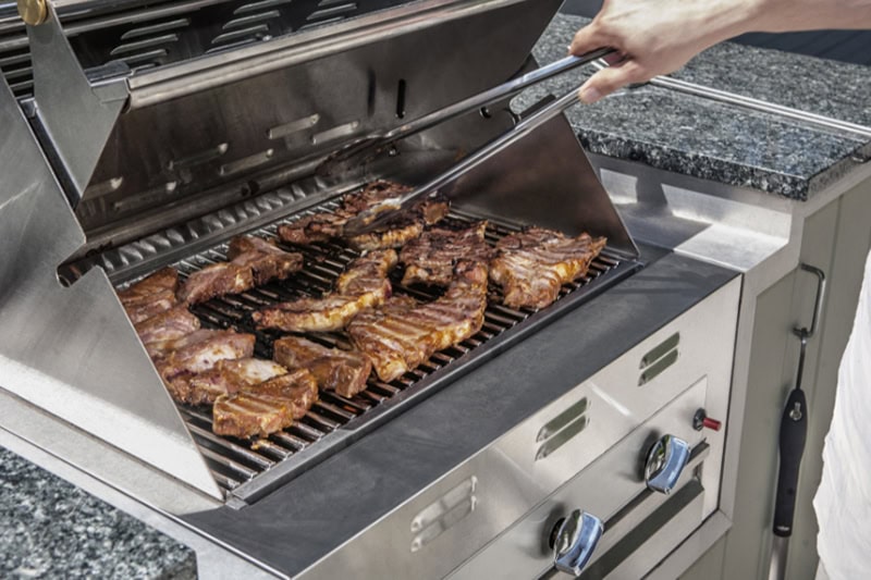 propane gas grill with stakes cooking.